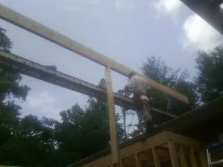 Carpenter setting a ridge beam over a new addition frame — Ice Dam Removal by Roofing Brothers in Madbury
