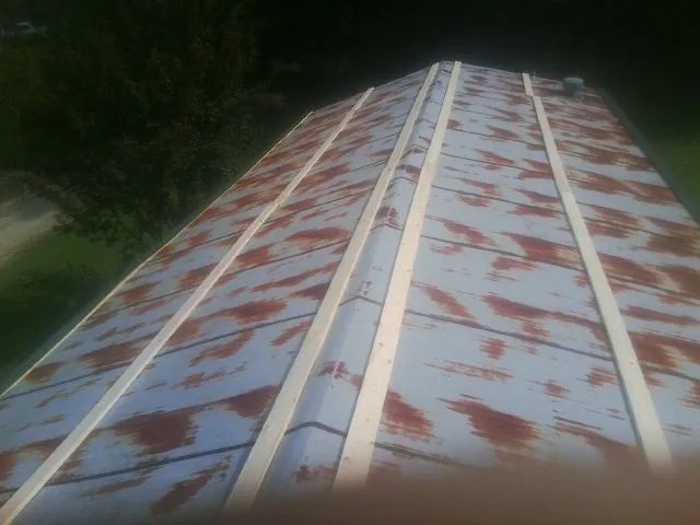 Rusted metal roof panels with new wood purlins before replacement — Storm Damage Roof Repair in Madbury by Roofing Brothers