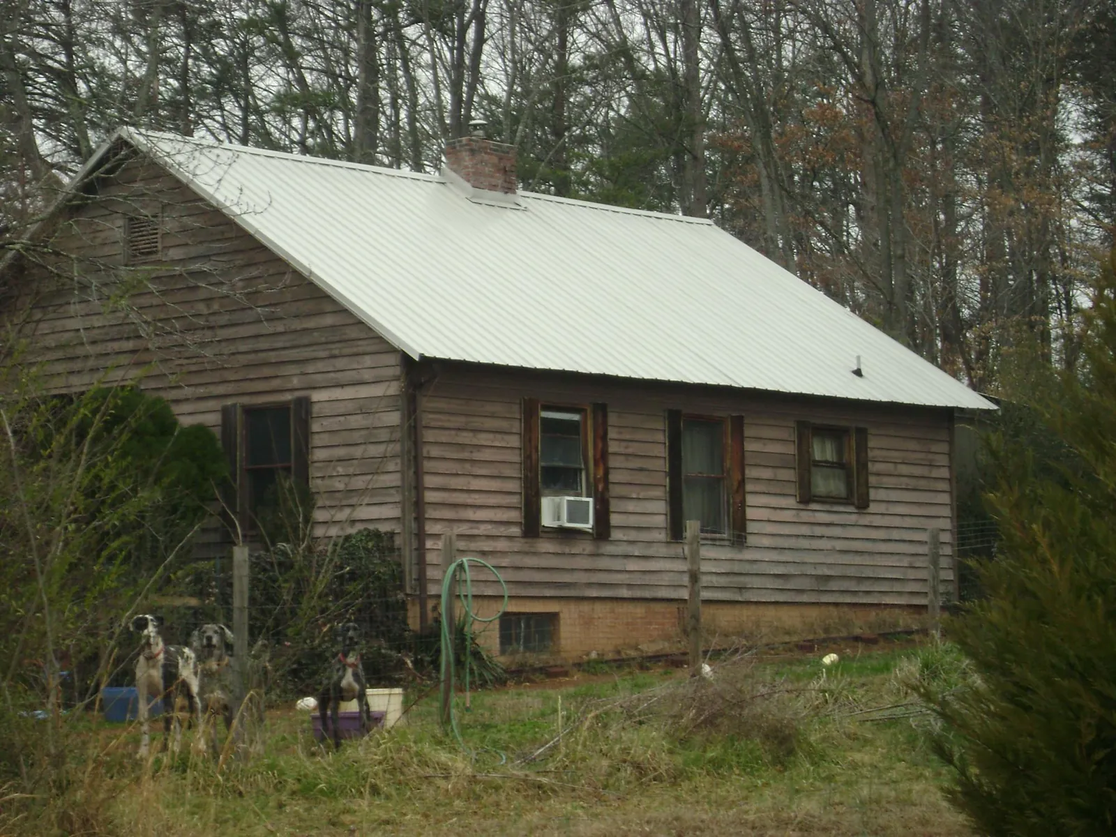 White metal roof on an old wood sided farmhouse, from a Metal Roof Installation job in Madbury